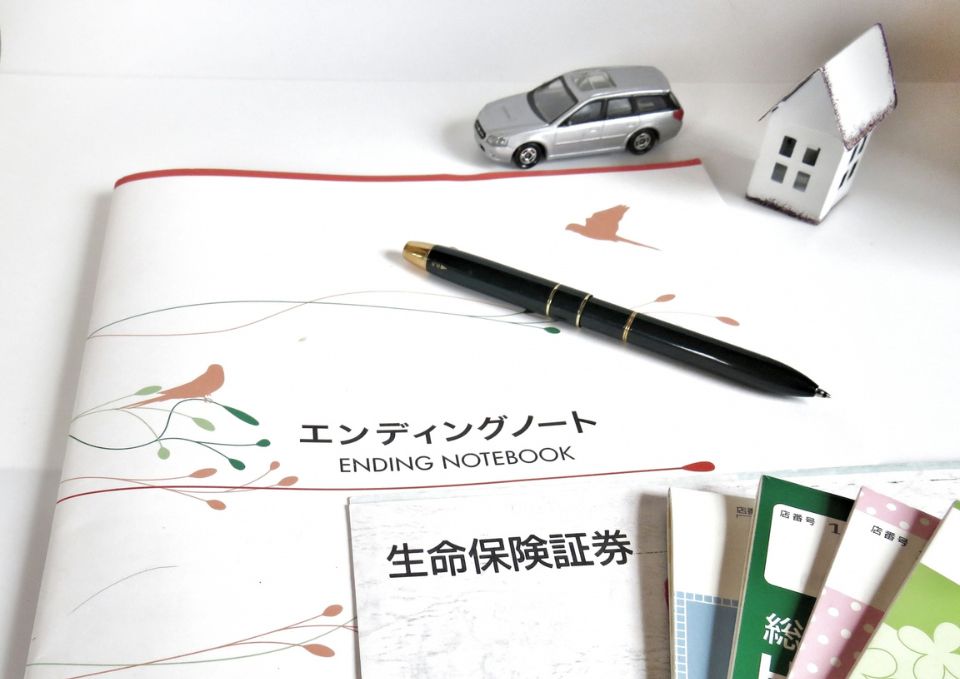 エンディングノートとペンを用意して書き始める様子