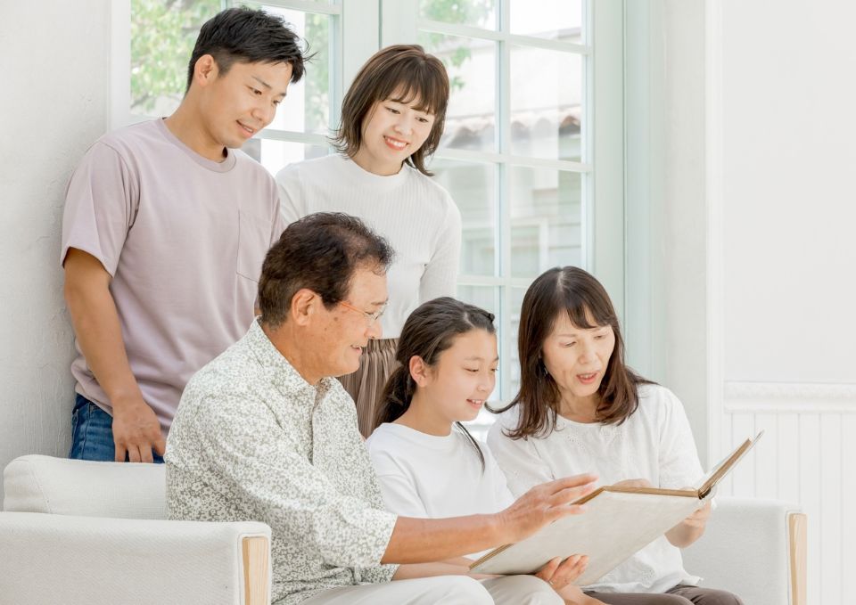 家族で写真を見ながら思い出を語る様子
